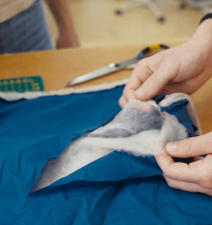 Hands crafting a Mammut jacket